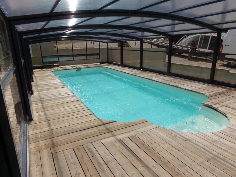 Abri haut adossé à la maison au-dessus d’une piscine