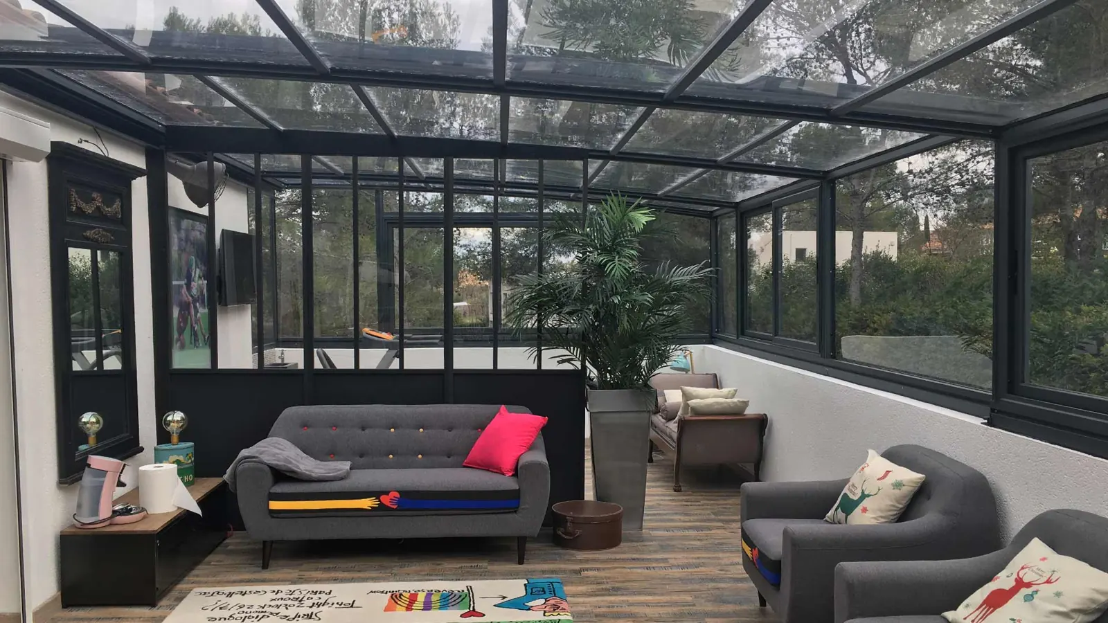 Abri de terrasse vitré abritant un salon extérieur